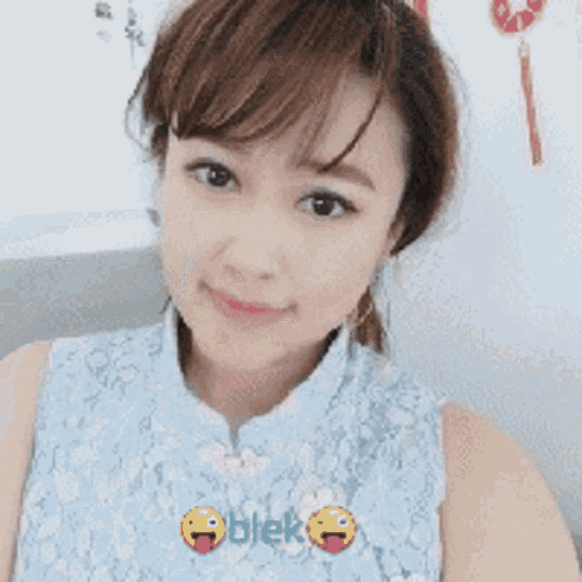 a woman wearing a blue lace top has a sticker on her chest that says blek
