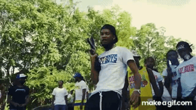 a man is holding a gun in front of a crowd of people .