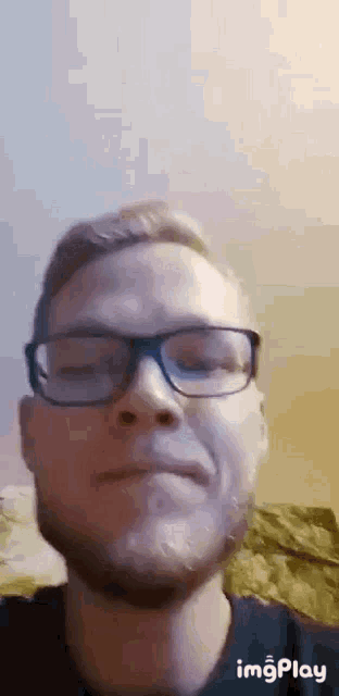 a close up of a man wearing glasses and a beard .