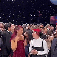 a woman in a red dress stands in a crowd