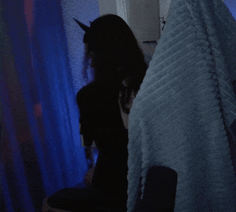 a woman wearing a cat ear headband looks at her phone