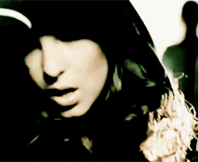 a close up of a woman 's face with a hood on