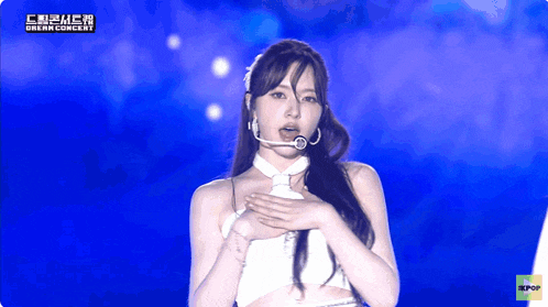 a woman stands on a stage with a microphone in her mouth and the words dream concert on the bottom
