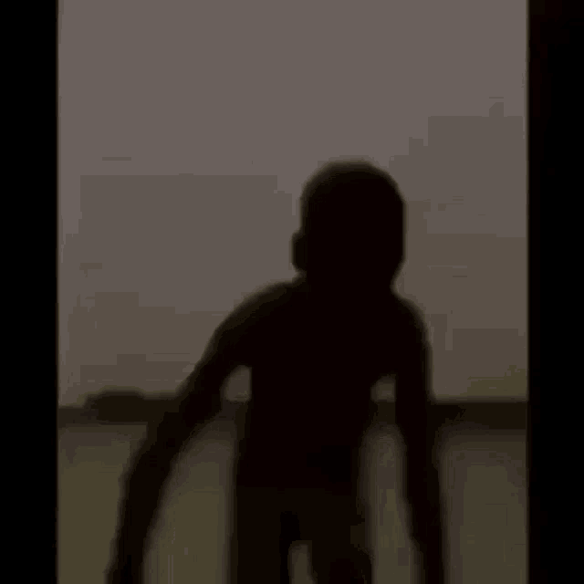 a blurry picture of a person standing on a boat in the water .