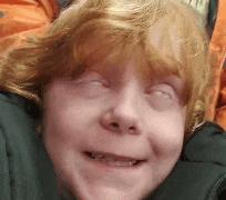 a close up of a child 's face with his eyes closed .