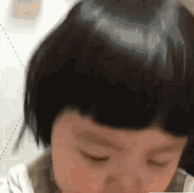 a close up of a child 's face with his eyes closed .