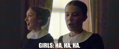 two women are standing next to each other in front of a mirror and laughing .