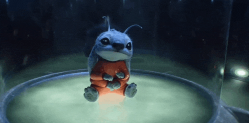 a blue and orange cartoon character is sitting in a glass dome