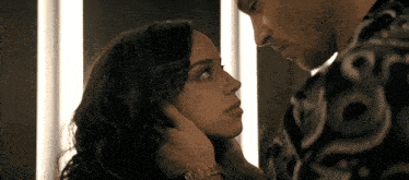 a man and a woman are looking at each other and the woman is wearing a watch