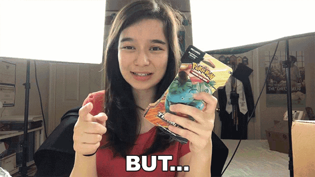 a woman is holding a pokemon card and pointing at the camera with the word but below her