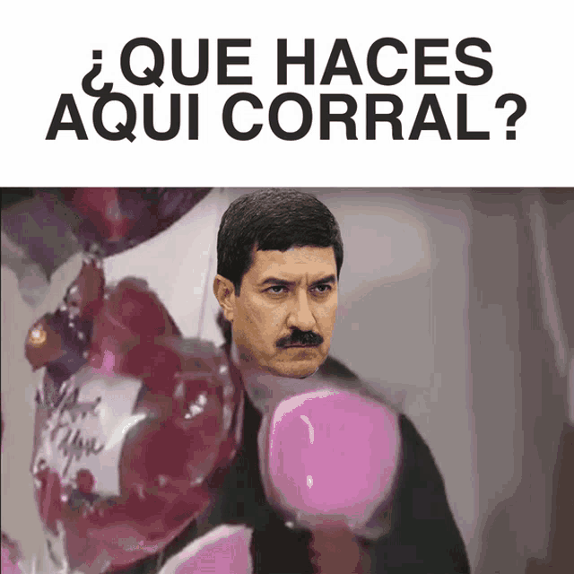 a man with a mustache is surrounded by pink heart shaped balloons and the words que haces aqui corral