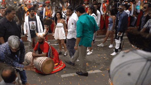 a man playing a drum in front of a crowd and a sign that says ' spotify '