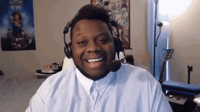a man wearing headphones and a white shirt smiles