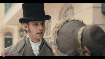 a man in a top hat talks to a woman in a hat