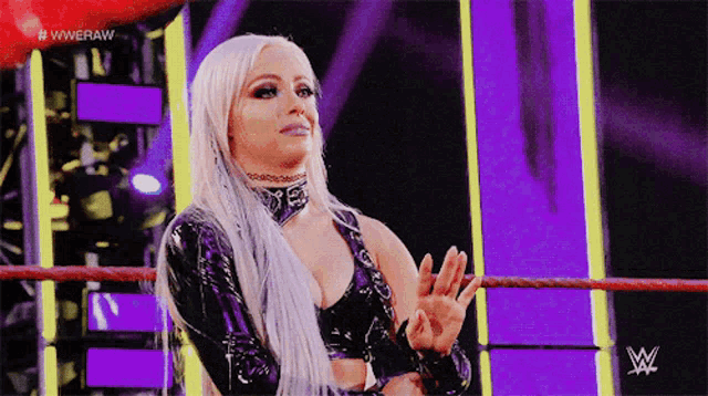 a woman in a wrestling ring with the letters wwe on the bottom