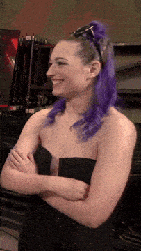 a woman with purple hair is wearing sunglasses and a black strapless top
