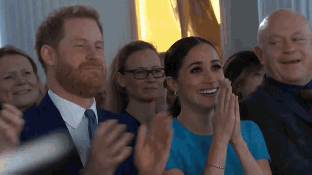 a group of people applauding including a man and a woman