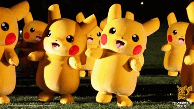 a group of pikachu mascots are dancing on a field