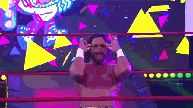 a wrestler is standing in a ring with his hands on his head