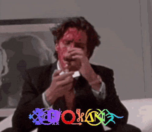 a man in a suit and tie with blood on his face is sitting on a couch with the word born in the background