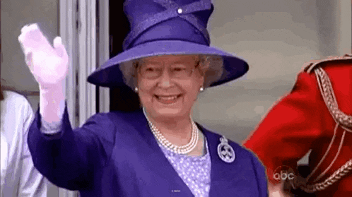 queen elizabeth ii is wearing a purple hat and gloves and waving .
