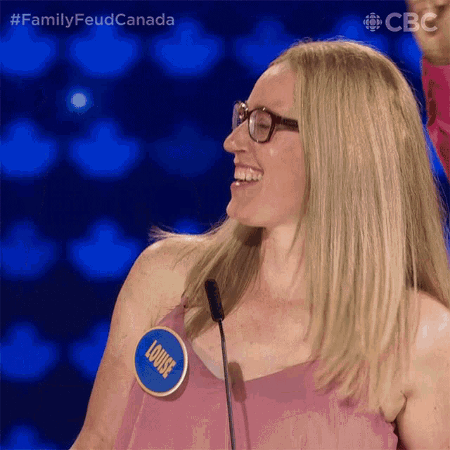 a woman with a name tag that says louise stands in front of a microphone