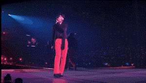a person in red pants is standing on a stage in front of a crowd