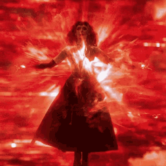 a woman in a red dress is standing in the middle of a red room .