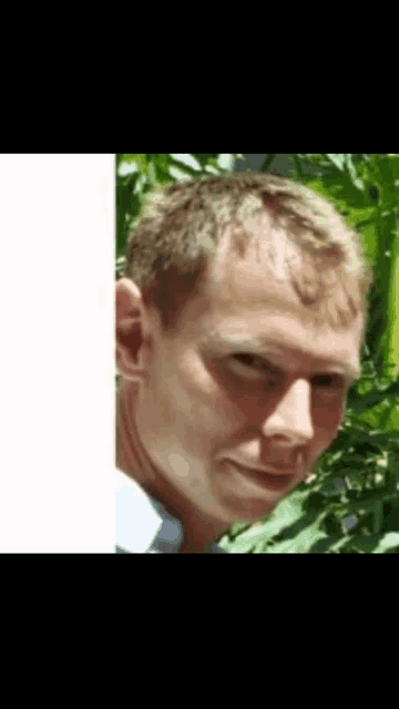 a close up of a man 's face with a green background