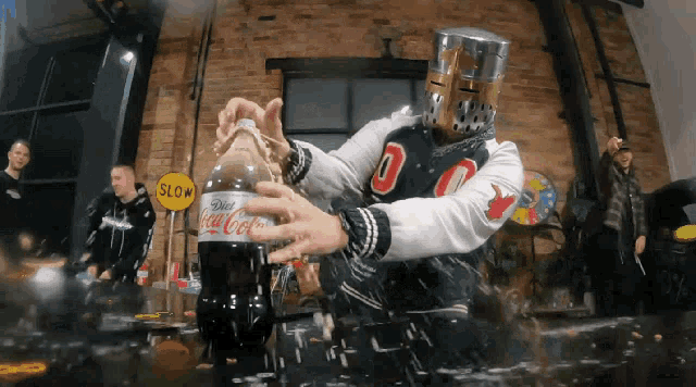 a man in a knight 's helmet is holding a bottle of diet coke