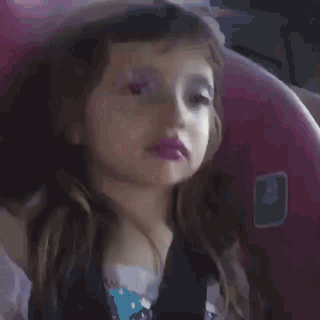 a close up of a child 's face with purple lipstick on it