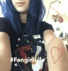 a woman with blue hair is wearing a black shirt and has a red heart tattoo on her arm .
