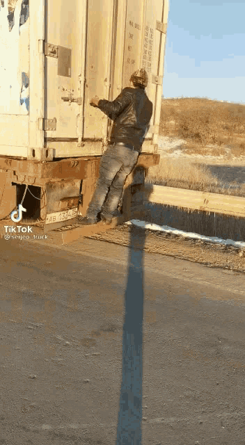 a man is standing on the back of a truck that has a tik tok sticker on it