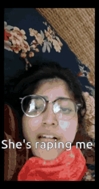a woman wearing glasses and a red scarf is laying on a bed and says she 's raping me .