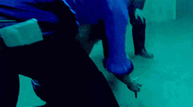 a man in a blue shirt is kneeling on the ground