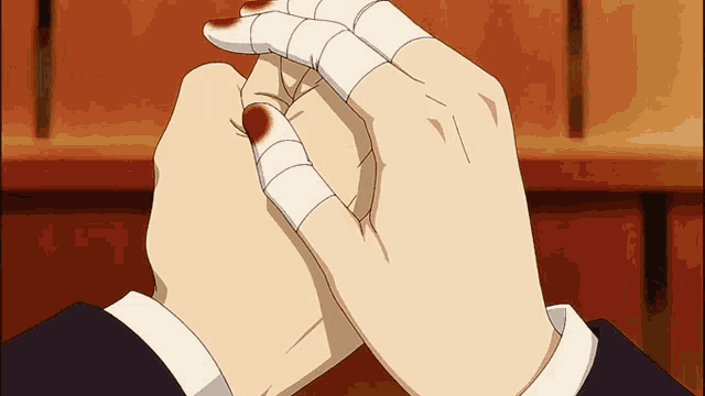 a person with bandages on their fingers holds another person 's hand with blood on it