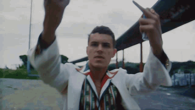 a man in a white jacket is holding a can of soda in his right hand