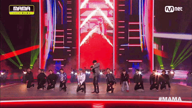 a group of people on a stage with a mnet logo on the top