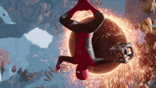 a man in a spiderman suit is hanging upside down in the air