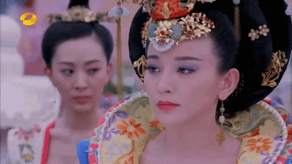 a woman in a traditional costume is looking at another woman
