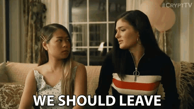 two women sitting on a couch with the words " we should leave "