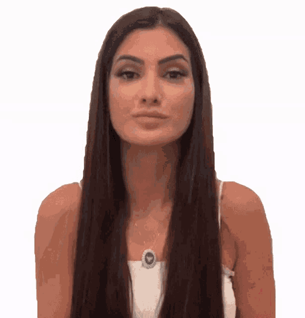 a woman with long brown hair is wearing a white top and a necklace