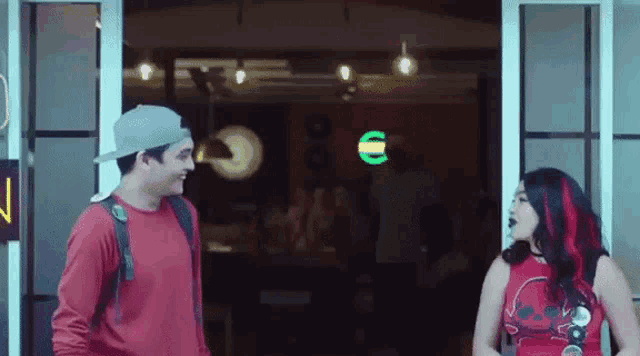 a man and a woman are standing next to each other in front of a door .