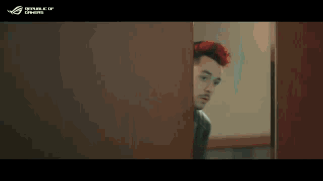 a man with red hair is peeking out from behind a door