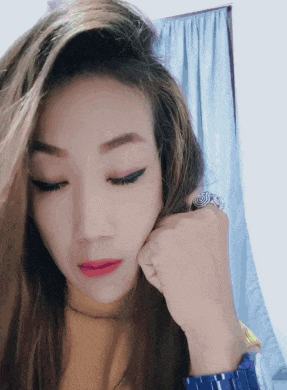 a close up of a woman 's face with a watch on her wrist