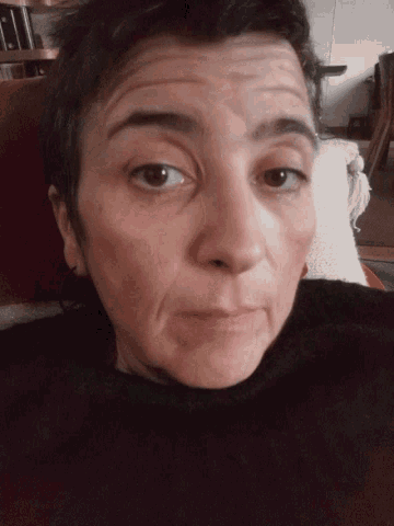 a close up of a person 's face with a slight smile
