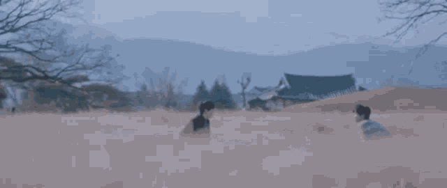 a group of men are standing next to each other in a field and fighting .