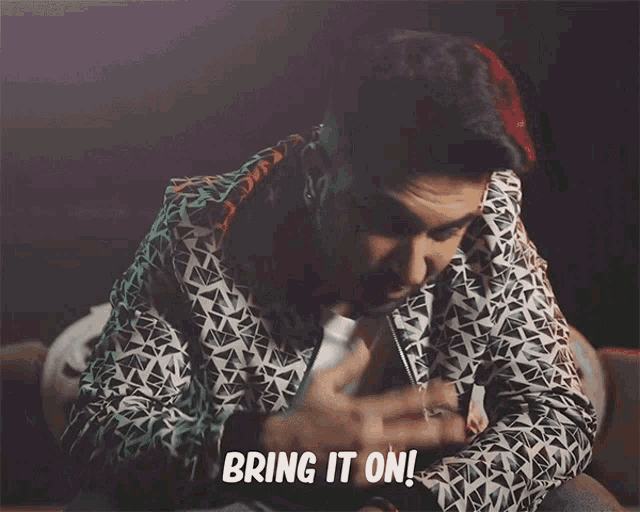 a man in a jacket says bring it on in a dark room