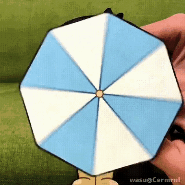 a person is holding a blue and white umbrella with wasu @ cermrnl written below it