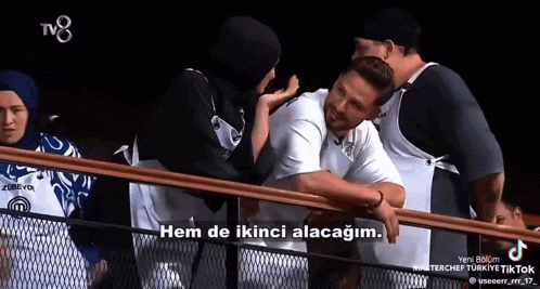 a group of people standing on a balcony with the caption " hem de ikinci alacagim " on the bottom